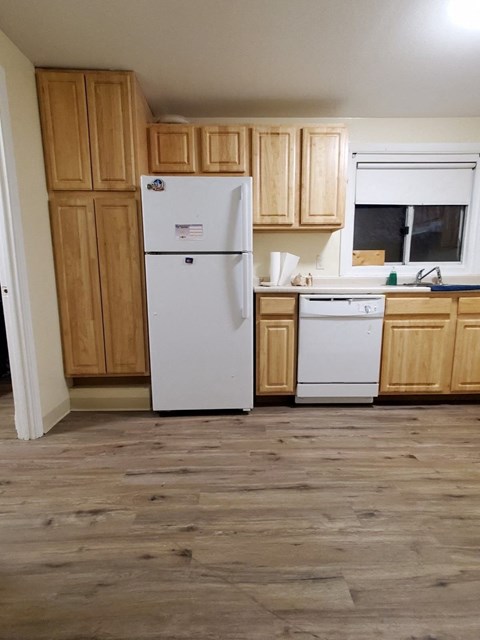 a kitchen with wooden cabinets and a white refrigerator